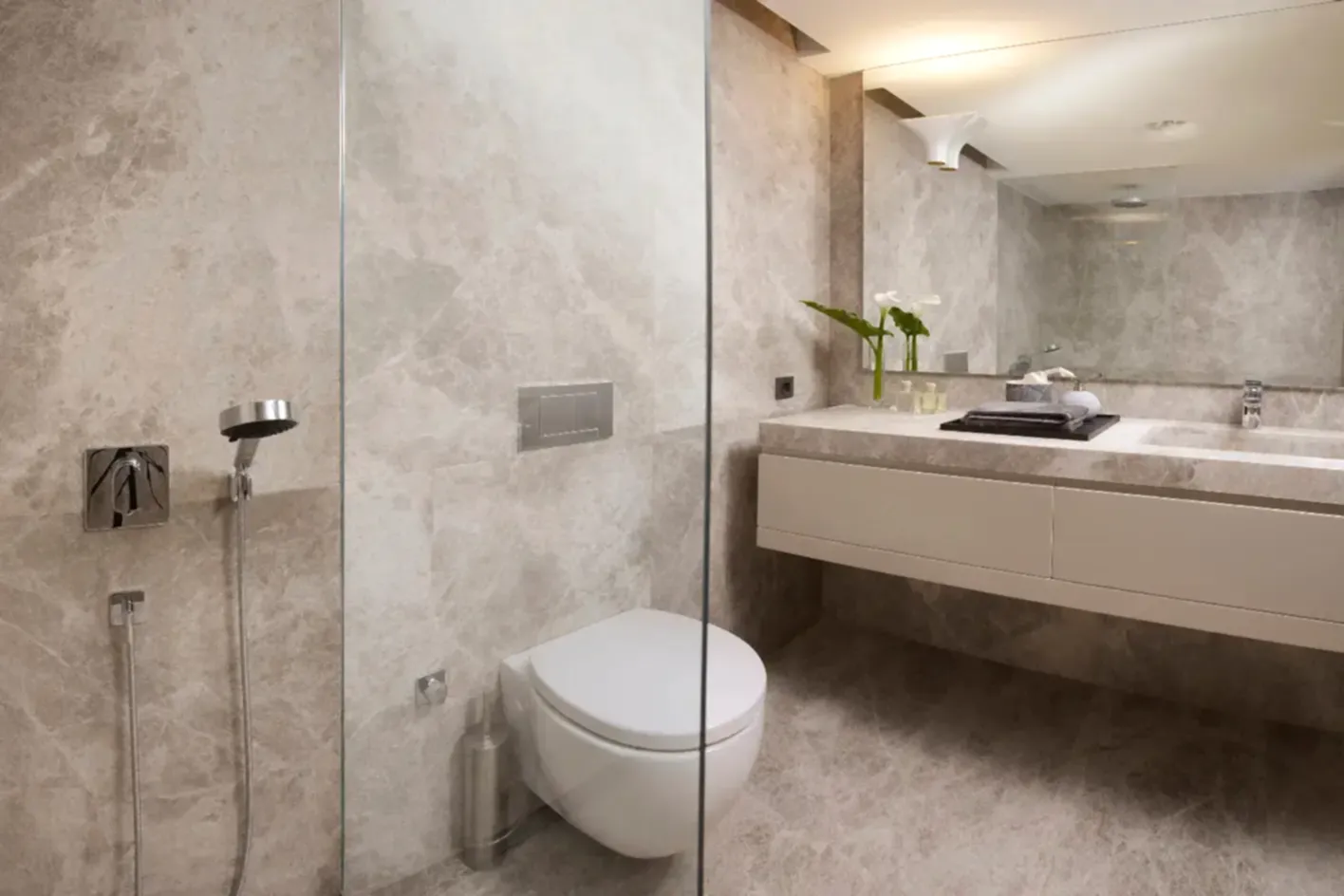 Mermer desenli modern banyo tadilatı ve cam duşakabin.